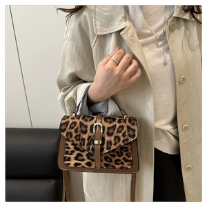 Close-up of leopard print handbag with metallic buckle and premium leather trim details