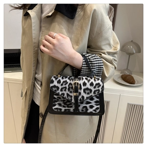 Fashionable leopard print mini square bag with metal clasp shown on a beige trench coat
