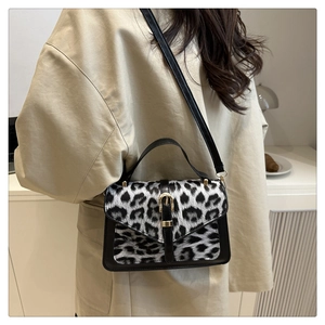 Chic leopard print crossbody bag with gold buckle detail worn with beige trench coat