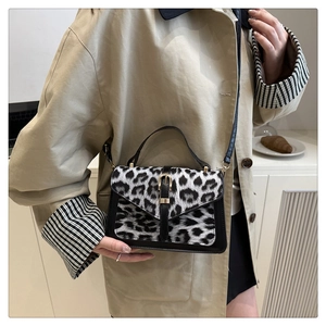 Close-up of leopard print crossbody bag with gold buckle detail and thin black shoulder strap
