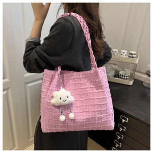 Close-up of pink checkered bubble tote bag with woven handles and cloud charm