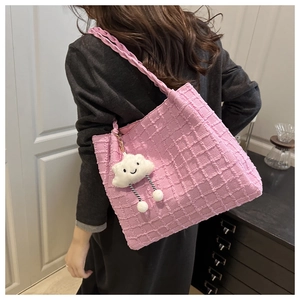 Pink large tote bag with waffle texture and cloud pendant shown on model shoulder
