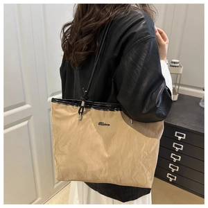 Détail du sac cabas plissé kaki avec de fines lanières noires et un logo discret