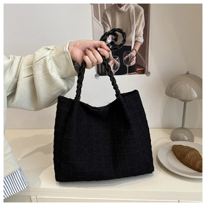Vue détaillée du sac cabas noir en tissu texturé avec des poignées en corde tressée