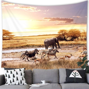 Detailed view of an African elephant sunset tapestry hung above a modern gray sofa