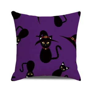 Close-up of purple Halloween cushion cover with repeating black cat and wizard hat pattern