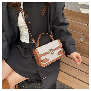 Detail of vintage canvas and leather crossbody bag with metal lock and double buckle straps