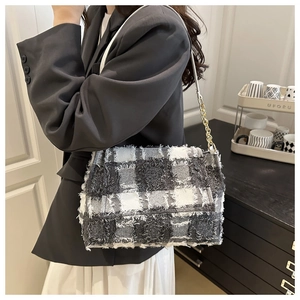 Détail du sac bandoulière en tweed à damier avec bords effilochés et chaîne dorée