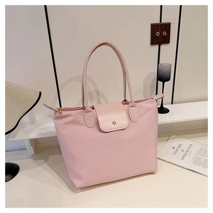 Détail du sac fourre-tout en nylon rose avec poignées en cuir et bouton-pression en métal