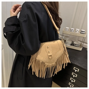 Détail du sac bandoulière vintage en daim camel avec de longues franges et boucle en D dorée