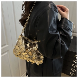 Gros plan sur la texture des paillettes dorées et la chaîne métallique du sac bandoulière