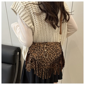 Detail of vintage leopard print crossbody bag featuring long fringe and gold ring accent