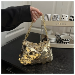 Detailed view of luxury gold sequin clutch bag with metallic chain strap and layered texture