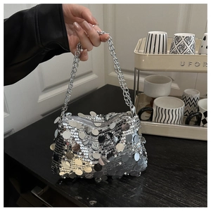 Close-up of sparkling silver sequin handbag with a thick metallic chain strap