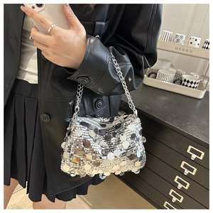 Detail of silver sequin chain bag showing reflective texture and metallic shoulder strap