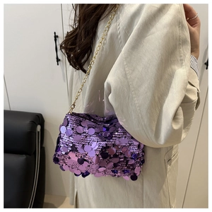 Détail du sac bandoulière à paillettes violettes avec chaîne dorée et texture brillante