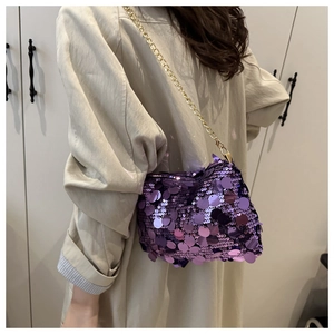 Détail d'un sac à bandoulière en paillettes violettes avec chaîne dorée sur mannequin