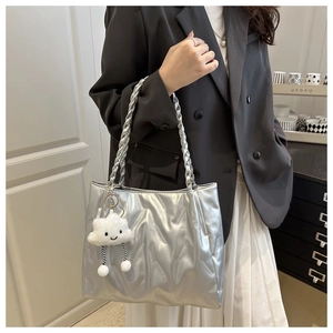 Silver quilted tote bag featuring woven rope handles and a plush cloud charm detail