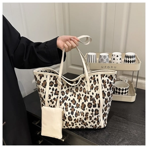 Detailed shot of leopard print tote bag with cream leather straps and matching pouch