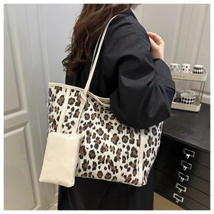 Detail of leopard print tote bag with a small white pouch on a model shoulder