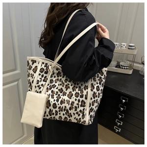 Detail of leopard print tote bag with small matching zipper pouch and white trim