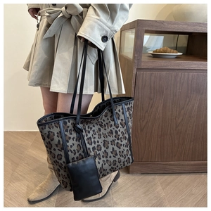 Detail view of leopard print tote bag with black leather trim and matching coin purse