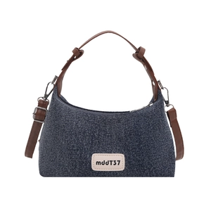 Vintage denim half-moon underarm bag with brown leather handle and metal branding logo