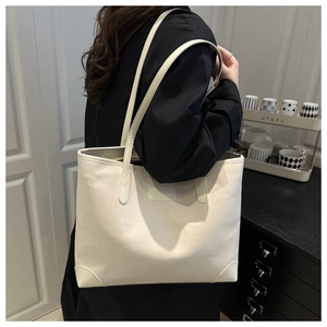 Detail view of cream faux suede tote bag featuring reinforced bottom and side carry