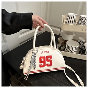 Detail of off-white crescent bag with red Los Angeles print and silver chain accessory