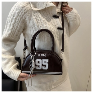 Detail of dark brown leather Boston bag with Los Angeles print and metal chain decor
