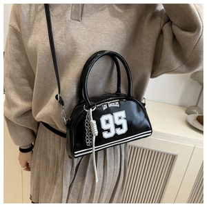 Detail of black patent leather bowling bag with Los Angeles 95 print and silver chain tassel