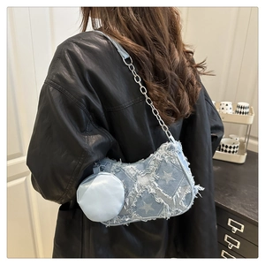 Dettaglio borsa a spalla in denim azzurro con stelle bianche e bordi sfrangiati
