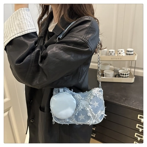 Détail du sac sous l'aisselle en denim bleu clair avec motifs d'étoiles et chaîne
