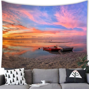 Detailed close-up of a sunset beach wall tapestry above a modern grey sofa in a living room
