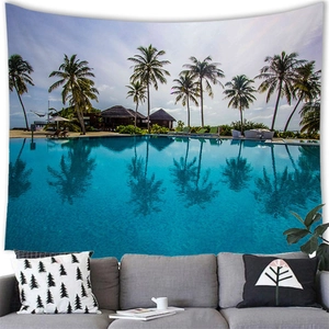 Tropical sunset beach wall tapestry featuring palm trees and pool above a grey sofa