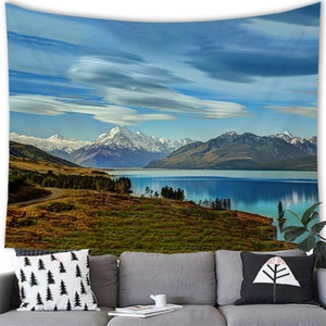 Scenic tapestry with mountains and lake hanging above a sofa in a modern living room