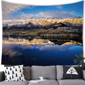 Detailed view of scenery tapestry above modern sofa showing mountain and lake reflections