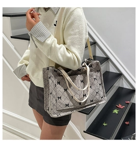 Detail of ribbon print tote bag with diamond stitching and adjustable shoulder strap