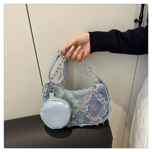 Dettaglio della borsa a tracolla in denim azzurro con motivo a scacchi e stelle ricamate