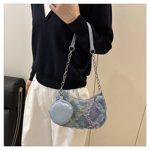 Dettaglio borsa a spalla in denim con stelle, catena in metallo e borsellino coordinato