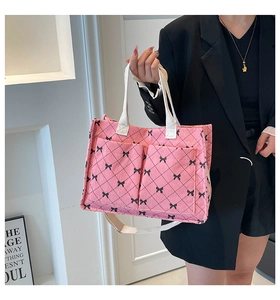 Detail of pink corduroy tote bag with bow patterns and adjustable shoulder strap