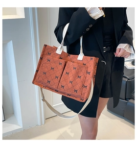 Detail view of caramel corduroy tote with black bow prints and quilted texture