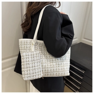 Sac fourre-tout en tweed blanc avec pochette assortie porté par un mannequin