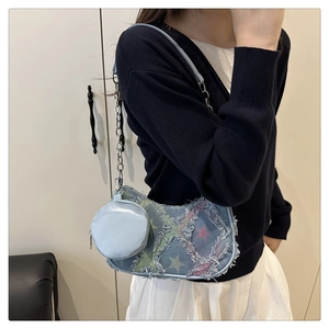 Detail of star-patterned denim baguette bag with chain strap and round coin purse pouch