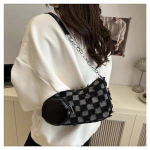 Détail du sac sous le bras en denim damier avec chaîne argentée et mini porte-monnaie