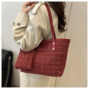 Detail of red tweed tote bag with gold thread weaving and matching leather strap