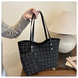 Close-up of black and gold tweed tote bag with leather handles and inner pouch