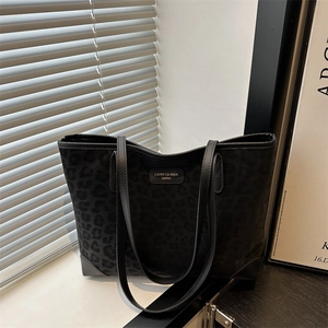 Minimalist black leopard print suede tote bag with leather handles in natural light