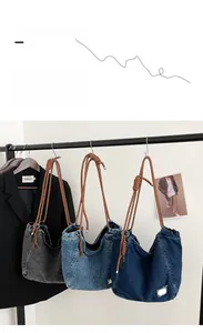 Close-up of denim tote bags in three colors with thick woven rope shoulder straps