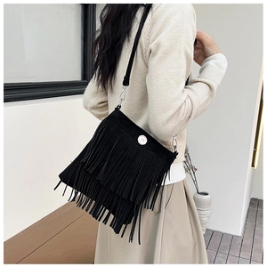 Detail of bohemian black crossbody bag featuring long double-layer tassels and metal buckle